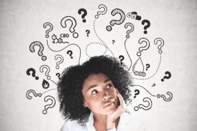Young girl surrounded by question marks representing Essential Questions to Ask About CBD.