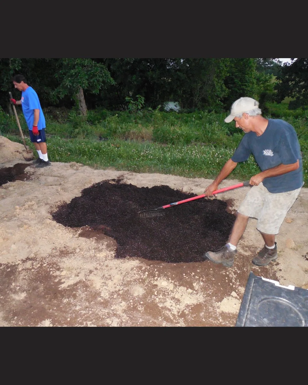 Bill Polyniak raking soil with Dave in the background while preparing to plant hemp in Kentucky